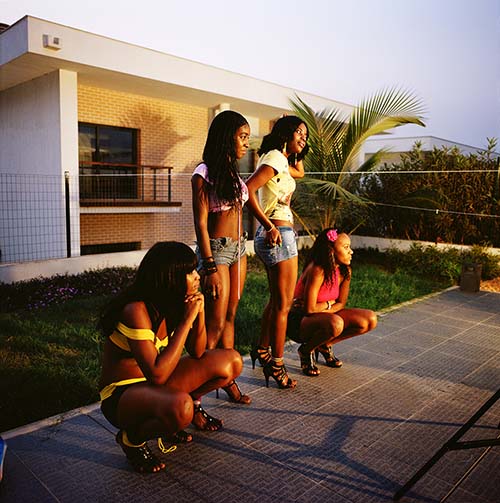 Angola, Four scantily dressed women watch on during the production of a Kuduru/Kuduro music video being shot at a private villa on the outskirts of Luanda that is worth in the region of USD 6,000,000. © Alfredo D'Amato / Panos Pictures