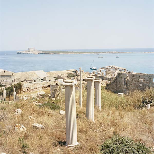 © Francesco Millefiori. Finte colonne. Sullo sfondo un'antica tonnara e L'isola delle Correnti. Porto Palo (SR), Agosto 2011